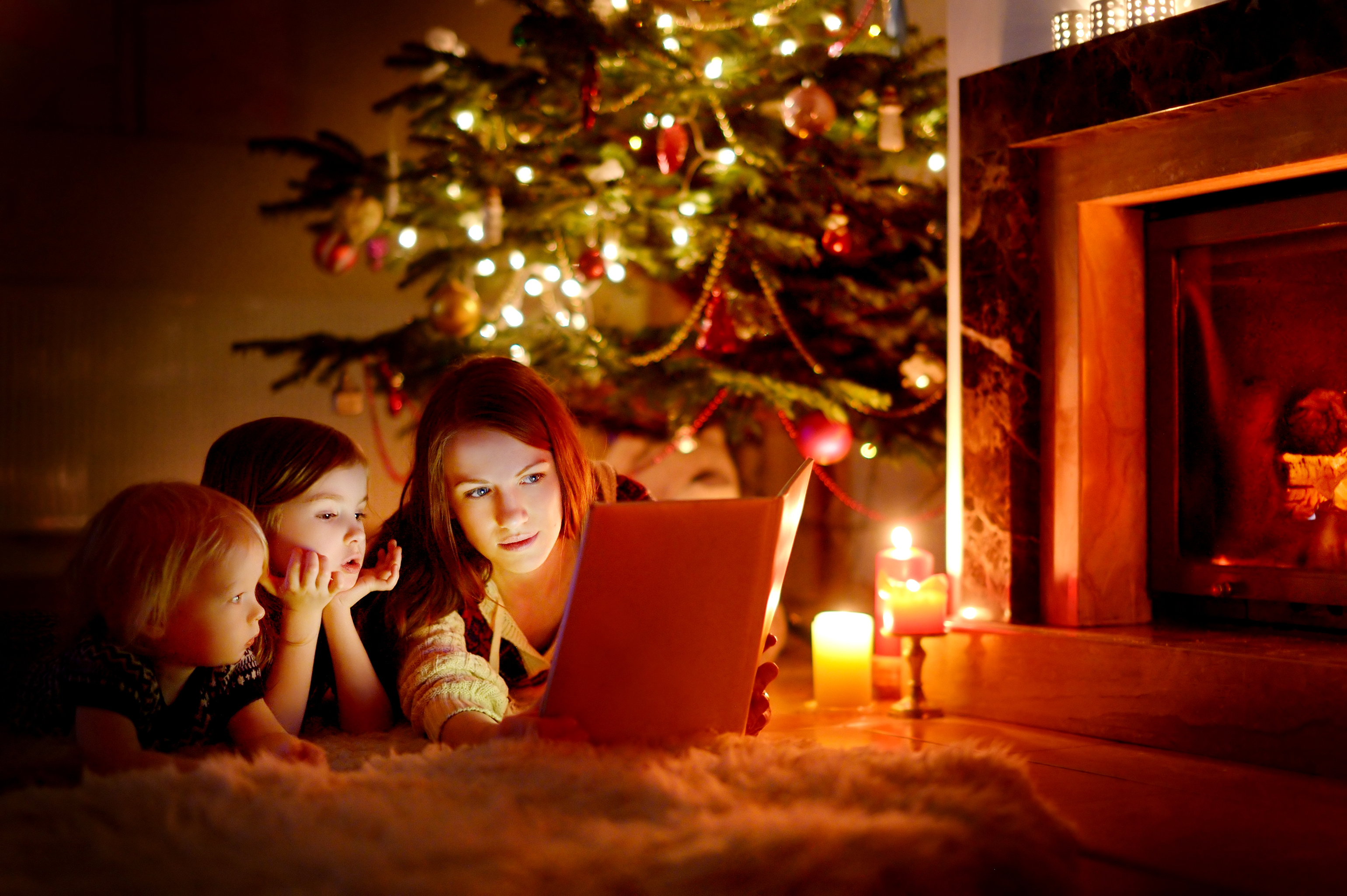 mother-and-daughters-reading-book-on-christmas