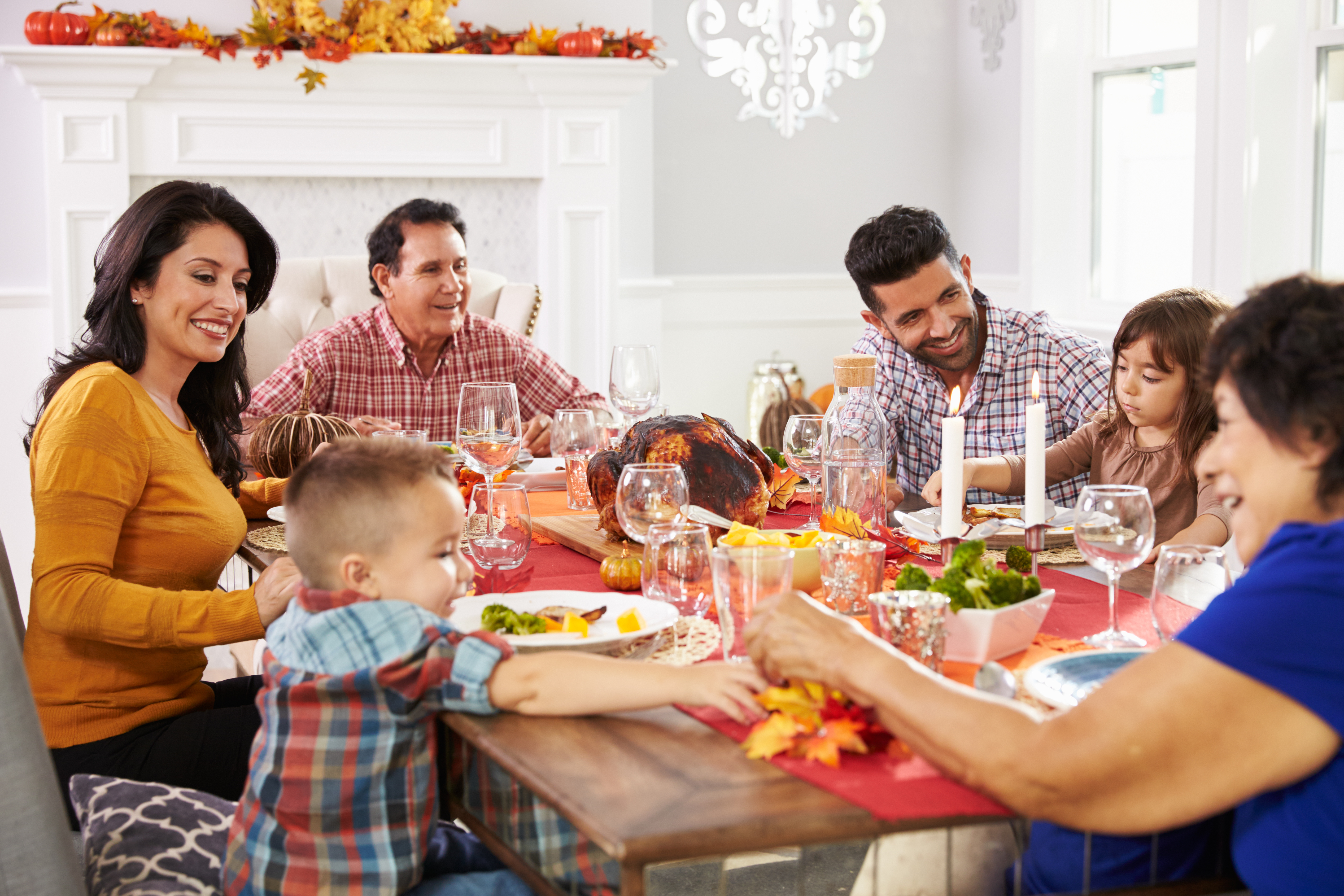 family-with-grandparents-enjoying-thanksgiving-meal-at-table